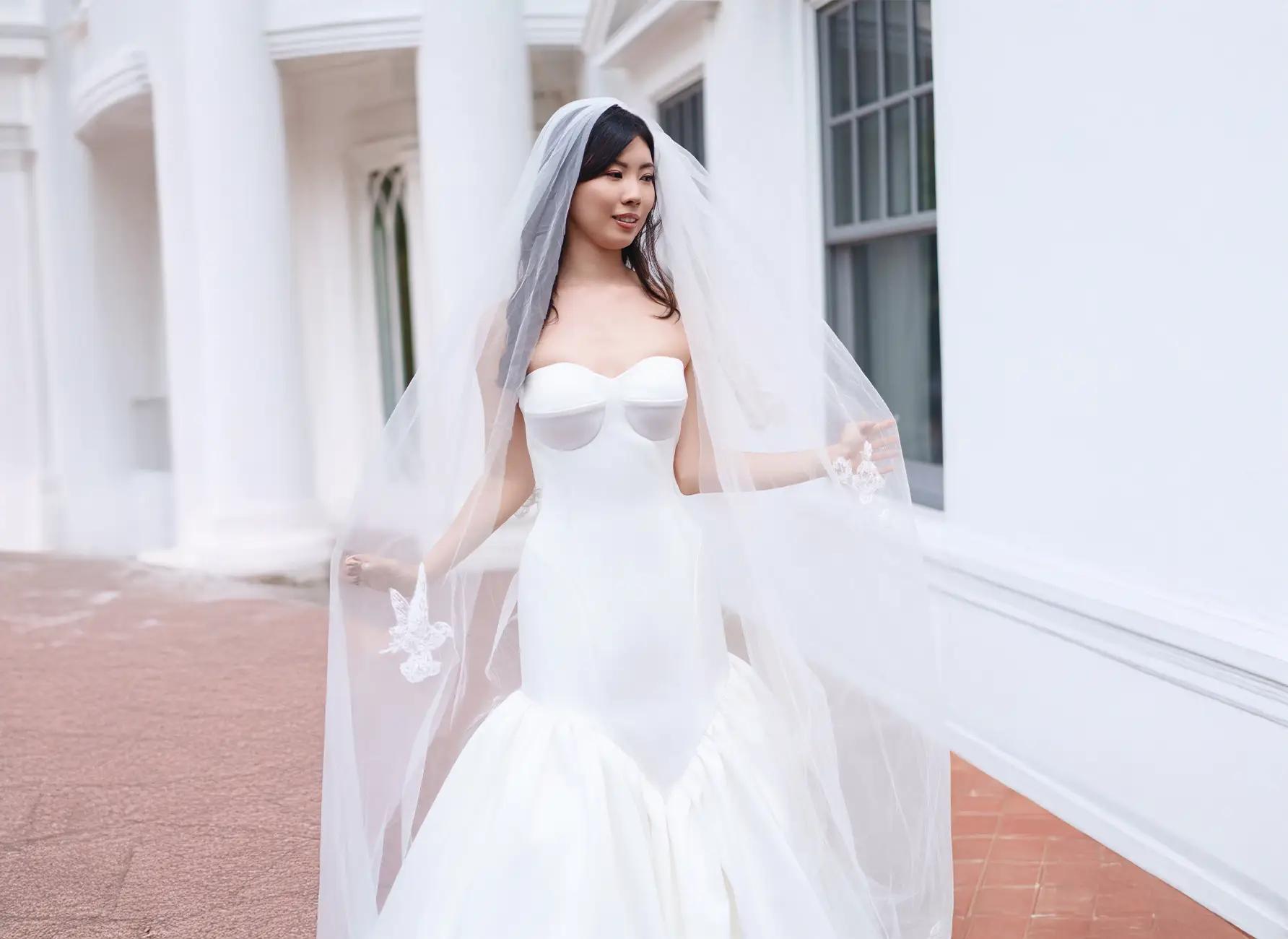 Model wearing a white gown by Andrea Osei